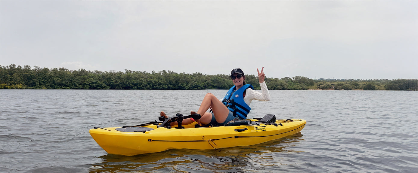 woman in pedal kayak giving a peace sign with her hand